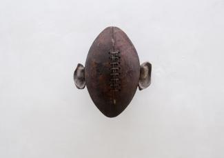 Michael E Smith, Untitled, 2014. Whale ear-bone fossil, football. Image courtesy of the artist and Andrew Kreps Gallery, New York.