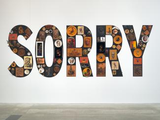 Tony Albert, Girramay people, Sorry, 2008. Found kitsch objects applied to vinyl letters, 99 objects: 200 x 510 x 10cm (installed). The James C Sourris, AM, Collection. Purchased 2008 with funds from James C Sourris through the Queensland Art Gallery Foundation. Collection: Queensland Art Gallery.